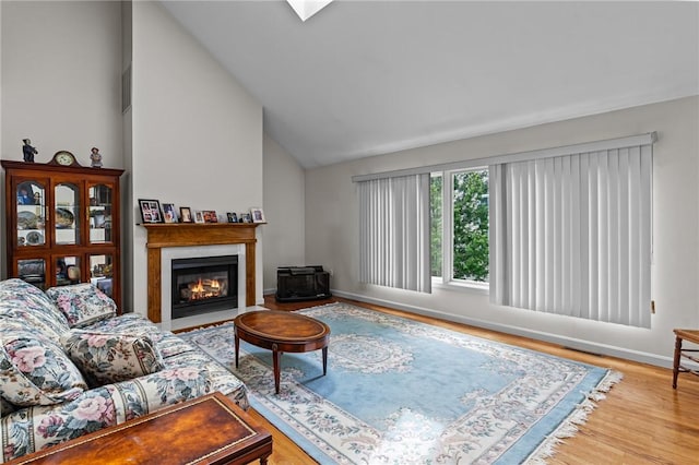 84 River Farms Dr Unit 84, West Warwick, RI 02893 - living room featuring lofted ceiling, baseboards, a fireplace with flush hearth, and wood finished floors