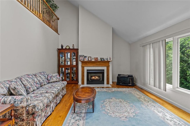 84 River Farms Dr Unit 84, West Warwick, RI 02893 - living room featuring wood finished floors, high vaulted ceiling, a fireplace with flush hearth, and baseboards