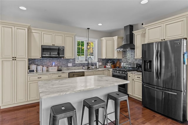 132 Theresa Marie Ave, Woonsocket, RI 02895 - kitchen with stainless steel appliances, wall chimney exhaust hood, cream cabinetry, a sink, and a kitchen breakfast bar