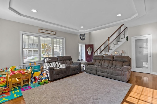 132 Theresa Marie Ave, Woonsocket, RI 02895 - living area featuring a tray ceiling, wood finished floors, recessed lighting, and stairway