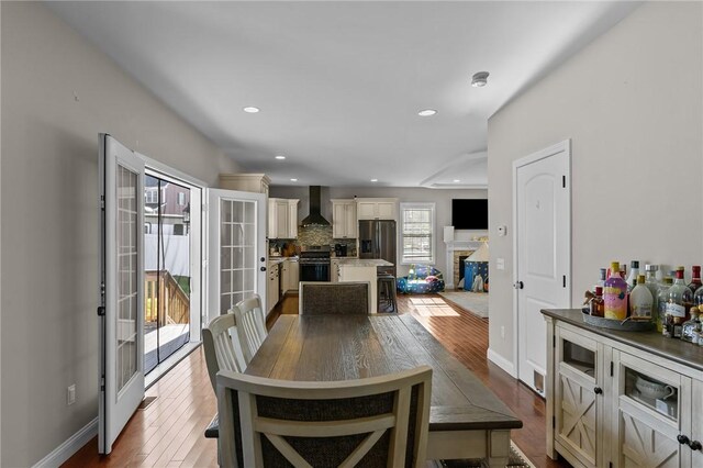 132 Theresa Marie Ave, Woonsocket, RI 02895 - dining space with dark wood-style floors, recessed lighting, a brick fireplace, and baseboards