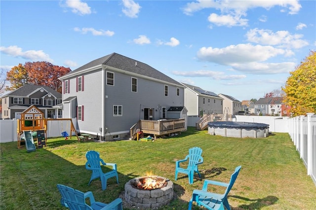 132 Theresa Marie Ave, Woonsocket, RI 02895 - back of house featuring a fire pit, a residential view, a deck, and a playground