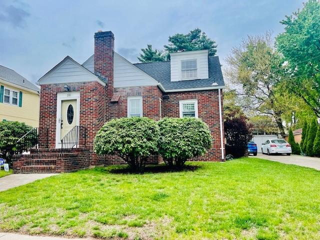 281 Auburn St, Cranston, RI 02910 - view of front of home featuring brick siding, a front yard, and a chimney