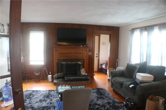 281 Auburn St, Cranston, RI 02910 - living area featuring healthy amount of natural light, wood walls, a fireplace with raised hearth, and wood finished floors