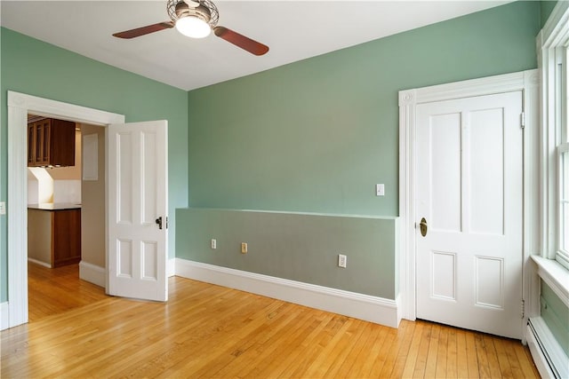 1291 Narragansett Blvd Unit 6, Cranston, RI 02905 - unfurnished bedroom with a baseboard radiator, light wood-style floors, baseboards, and a ceiling fan
