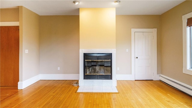 1291 Narragansett Blvd Unit 6, Cranston, RI 02905 - unfurnished living room featuring a baseboard heating unit, a multi sided fireplace, hardwood / wood-style flooring, and baseboards