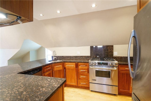 1291 Narragansett Blvd Unit 6, Cranston, RI 02905 - kitchen featuring appliances with stainless steel finishes, a sink, light wood-type flooring, dark stone counters, and brown cabinetry