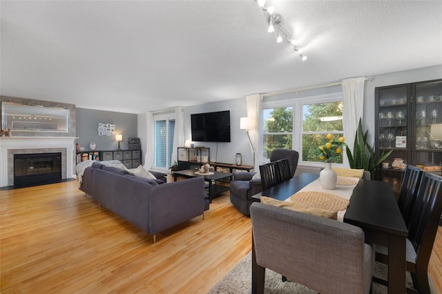 5390 Post Rd Unit 9, Warwick, RI 02818 - living room featuring light wood-type flooring, a textured ceiling, a fireplace with flush hearth, and rail lighting