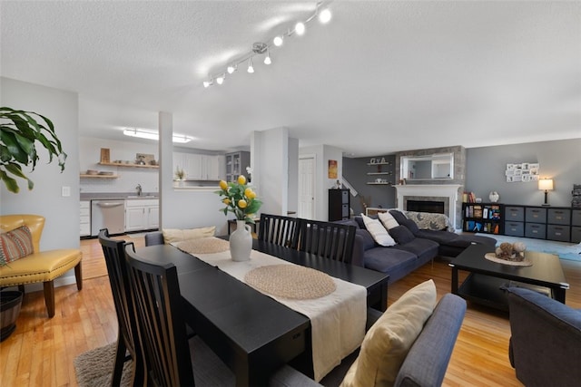 5390 Post Rd Unit 9, Warwick, RI 02818 - dining area featuring light wood-style flooring, a fireplace, and a textured ceiling