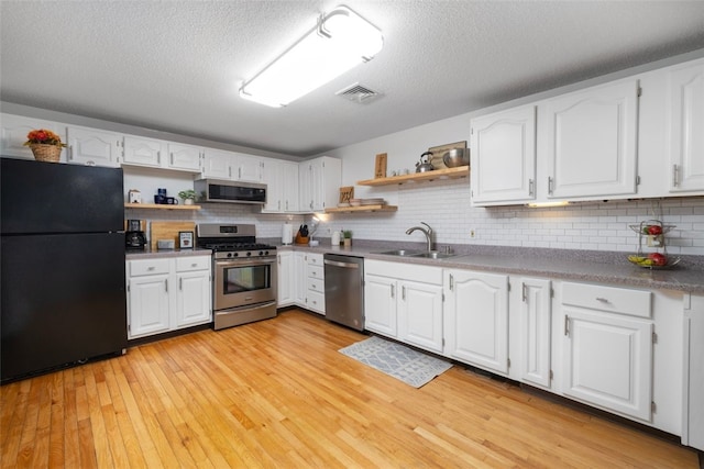 5390 Post Rd Unit 9, Warwick, RI 02818 - kitchen featuring appliances with stainless steel finishes, open shelves, a sink, tasteful backsplash, and white cabinetry