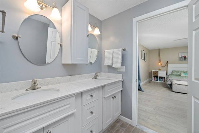 5390 Post Rd Unit 9, Warwick, RI 02818 - full bathroom with double vanity, ensuite bathroom, wood finished floors, baseboards, and a textured ceiling