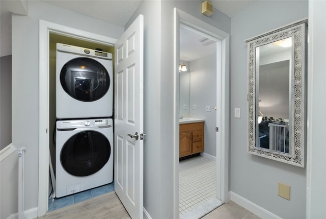 5390 Post Rd Unit 9, Warwick, RI 02818 - laundry area with stacked washer / drying machine, a textured ceiling, and baseboards