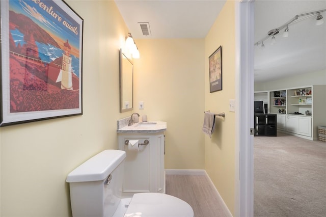 5390 Post Rd Unit 9, Warwick, RI 02818 - bathroom featuring toilet, vanity, baseboards, and track lighting