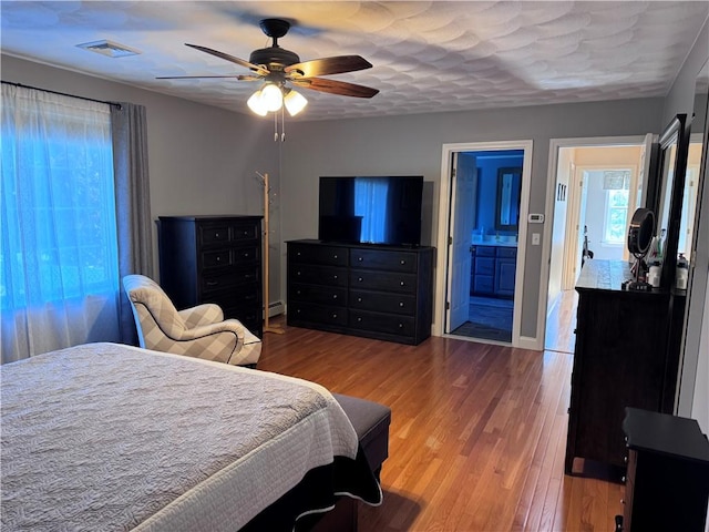 60 Farm Dr, Cumberland, RI 02864 - bedroom with wood finished floors, ceiling fan, ensuite bath, and a baseboard heating unit