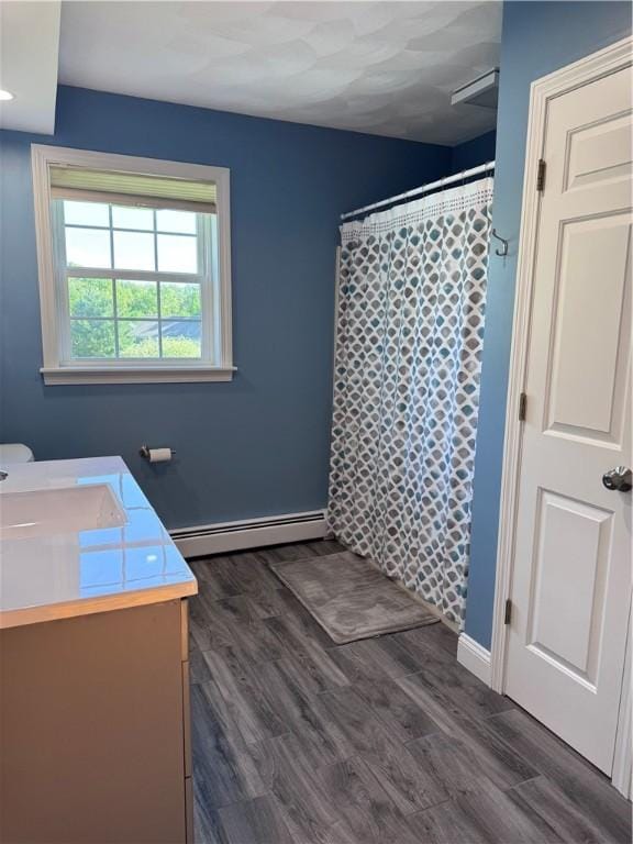 60 Farm Dr, Cumberland, RI 02864 - full bath with a baseboard heating unit, vanity, wood finished floors, curtained shower, and baseboards