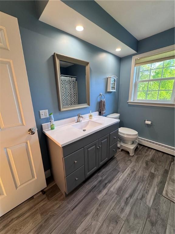 60 Farm Dr, Cumberland, RI 02864 - full bathroom with a baseboard heating unit, vanity, wood finished floors, toilet, and recessed lighting