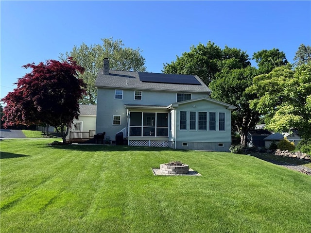60 Farm Dr, Cumberland, RI 02864 - rear view of house featuring a fire pit, a sunroom, roof mounted solar panels, a chimney, and a yard