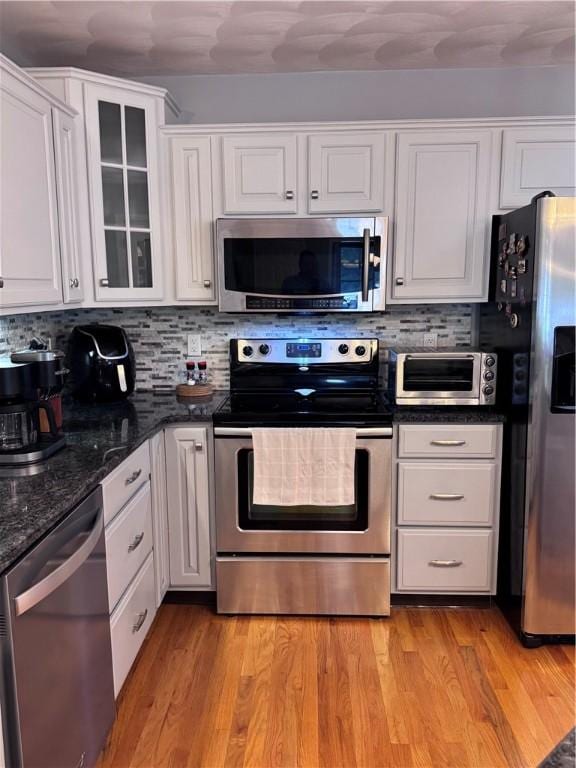 60 Farm Dr, Cumberland, RI 02864 - kitchen featuring stainless steel appliances, white cabinetry, decorative backsplash, and glass insert cabinets