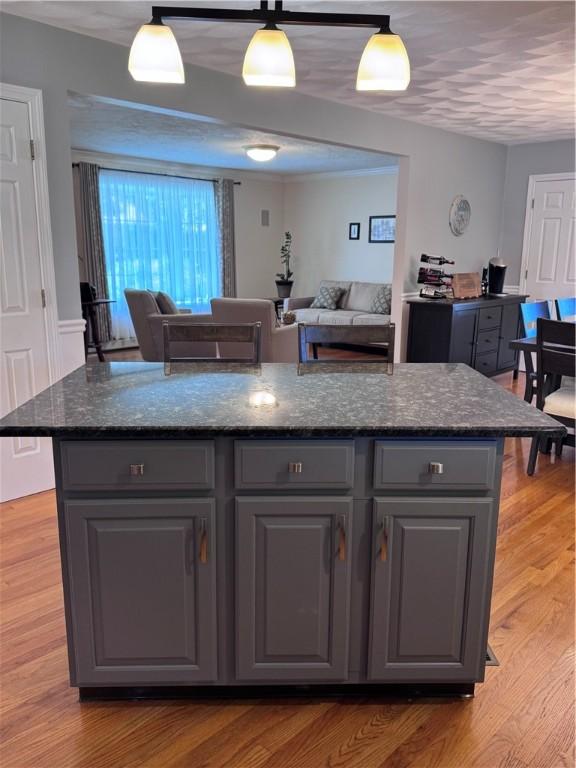 60 Farm Dr, Cumberland, RI 02864 - kitchen featuring gray cabinets, open floor plan, light wood-style flooring, and hanging light fixtures