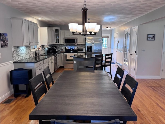 60 Farm Dr, Cumberland, RI 02864 - dining room featuring a chandelier, baseboards, and light wood-type flooring
