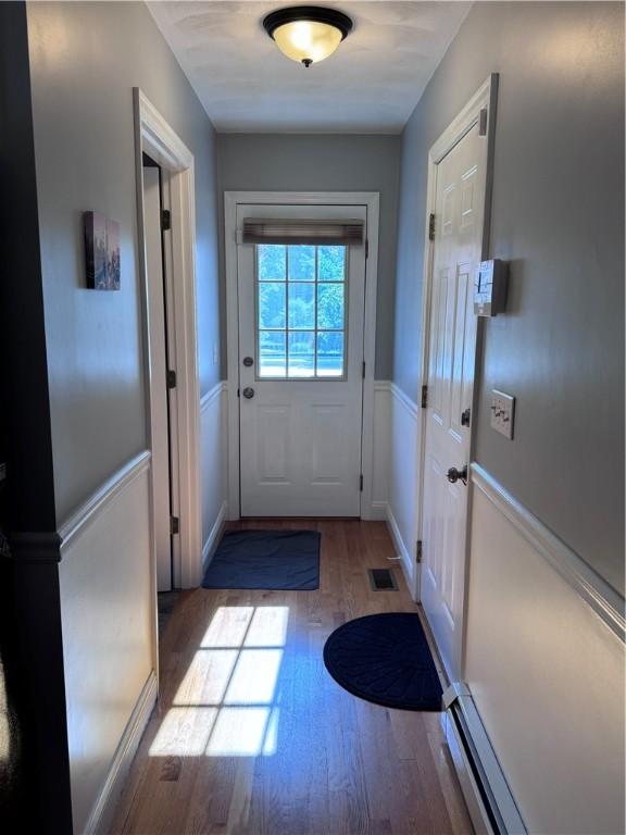 60 Farm Dr, Cumberland, RI 02864 - doorway to outside with wood finished floors and a wainscoted wall
