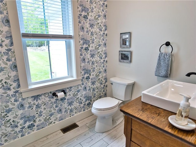 1 Hinter Way, Little Compton, RI 02837 - bathroom with wood finished floors, toilet, baseboards, wallpapered walls, and vanity