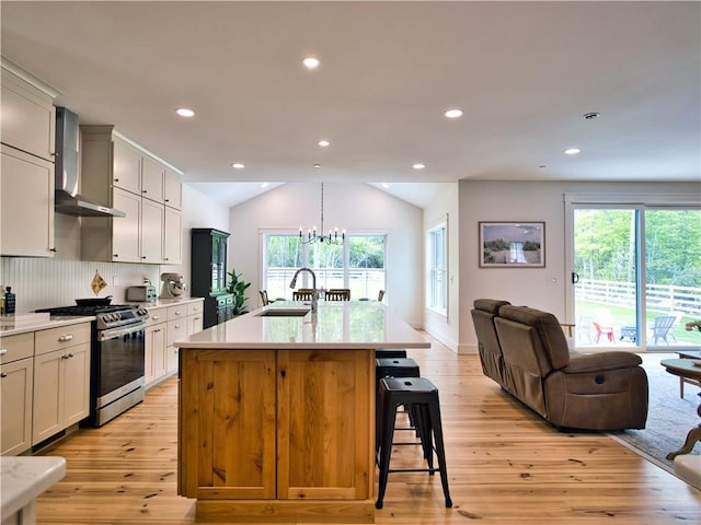 1 Hinter Way, Little Compton, RI 02837 - kitchen featuring gas range, wall chimney exhaust hood, a sink, open floor plan, and light wood-style flooring