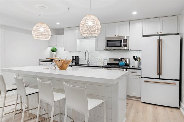 426 Spring St Unit B101, Newport, RI 02840 - kitchen featuring stainless steel appliances, backsplash, a kitchen island, a kitchen breakfast bar, and a sink