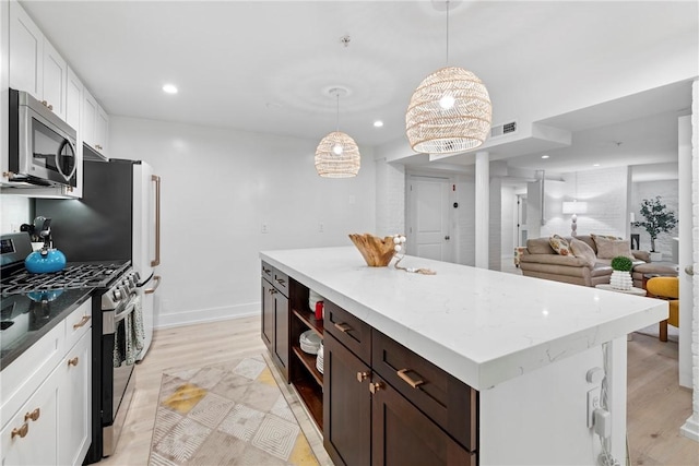 426 Spring St Unit B101, Newport, RI 02840 - kitchen with stainless steel appliances, white cabinetry, light wood-style flooring, recessed lighting, and a kitchen island