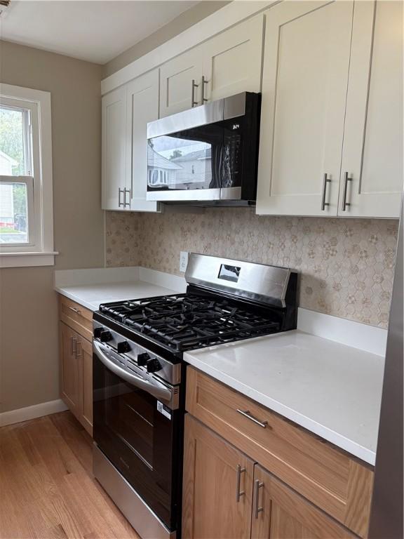 173 Martin St, East Providence, RI 02914 - kitchen with appliances with stainless steel finishes, light wood-style flooring, baseboards, and light countertops