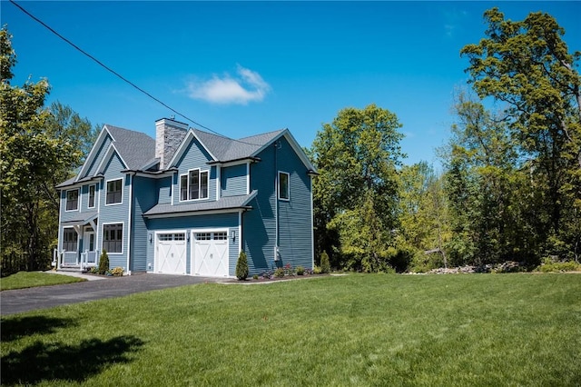 9 Chase Ln, Lincoln, RI 02865 - view of front of house featuring a chimney, a front lawn, asphalt driveway, and a garage