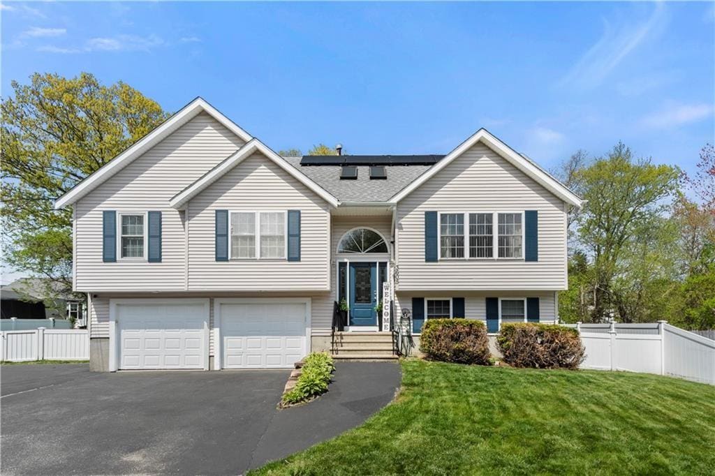 3605 Mendon Rd, Cumberland, RI 02864 - split foyer home featuring solar panels, a garage, and asphalt driveway