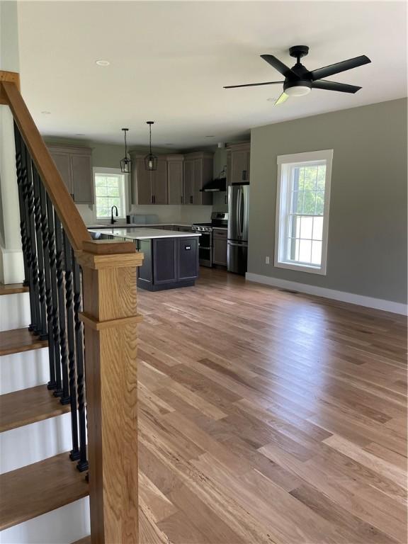 125 Fairview Ave, Hopkinton, RI 02832 - unfurnished living room with light wood-style flooring, ceiling fan, and stairway