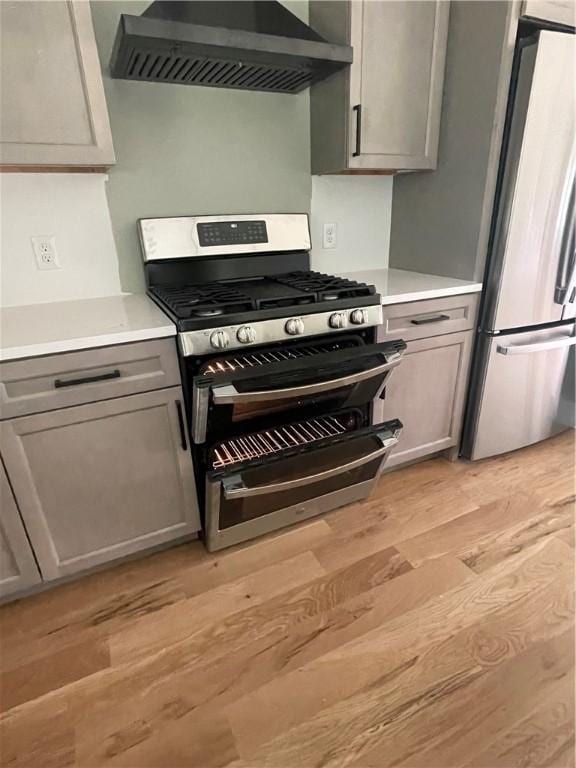 125 Fairview Ave, Hopkinton, RI 02832 - kitchen with appliances with stainless steel finishes, wall chimney exhaust hood, light wood-style floors, gray cabinetry, and light countertops