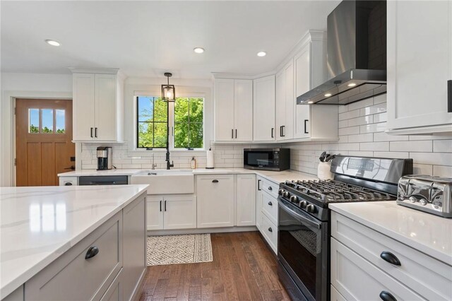 23 Hemlock St, Narragansett, RI 02882 - kitchen with wall chimney range hood, gas stove, a sink, light countertops, and white cabinetry