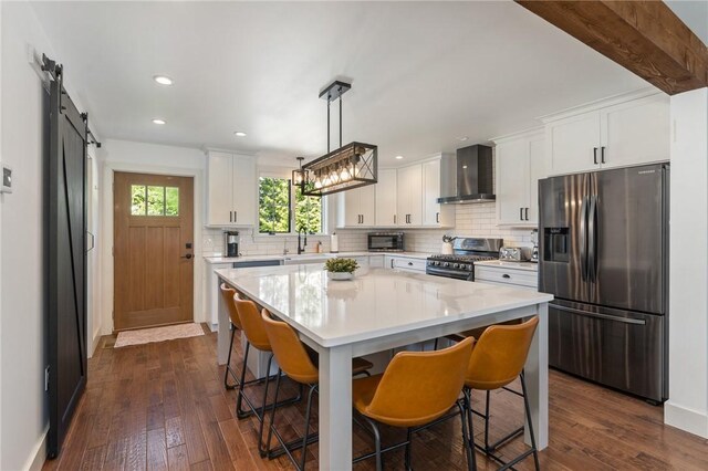 23 Hemlock St, Narragansett, RI 02882 - kitchen featuring stainless steel appliances, wall chimney range hood, decorative backsplash, a sink, and light countertops