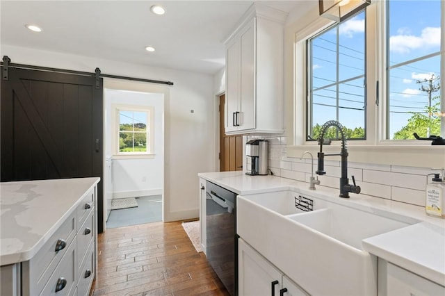 23 Hemlock St, Narragansett, RI 02882 - kitchen with stainless steel dishwasher, a sink, white cabinets, recessed lighting, and hardwood / wood-style floors