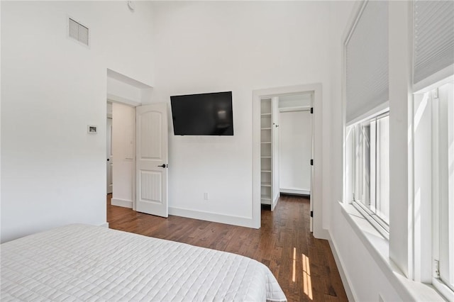 23 Hemlock St, Narragansett, RI 02882 - unfurnished bedroom featuring wood finished floors, a spacious closet, a high ceiling, baseboards, and a closet