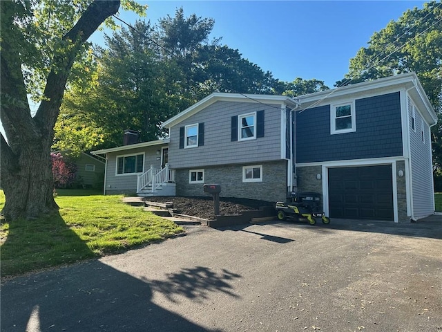 21 Baldwin Rd, Warwick, RI 02886 - tri-level home with asphalt driveway, a garage, and a front yard