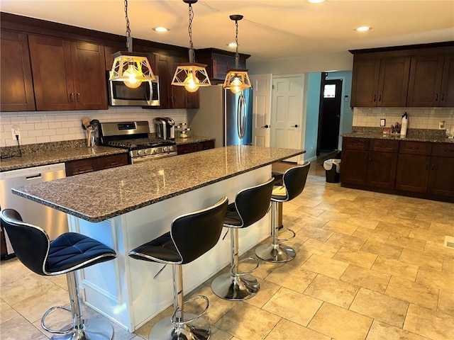 21 Baldwin Rd, Warwick, RI 02886 - kitchen featuring appliances with stainless steel finishes, decorative backsplash, a kitchen bar, recessed lighting, and a kitchen island