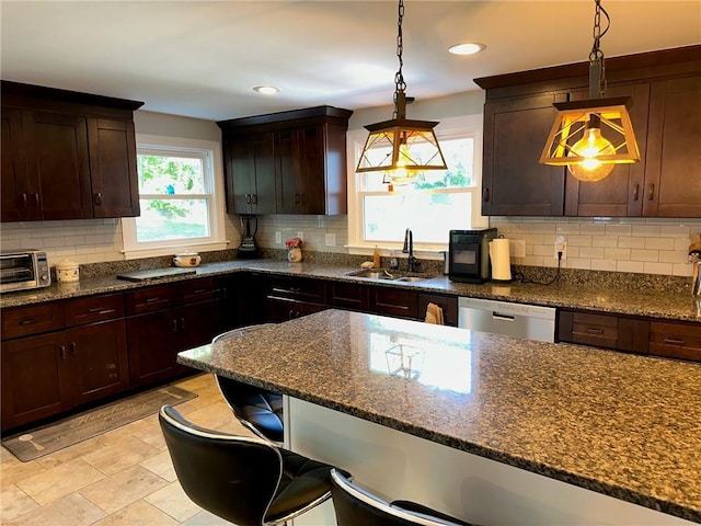 21 Baldwin Rd, Warwick, RI 02886 - kitchen featuring a sink, dishwasher, a kitchen breakfast bar, hanging light fixtures, and decorative backsplash