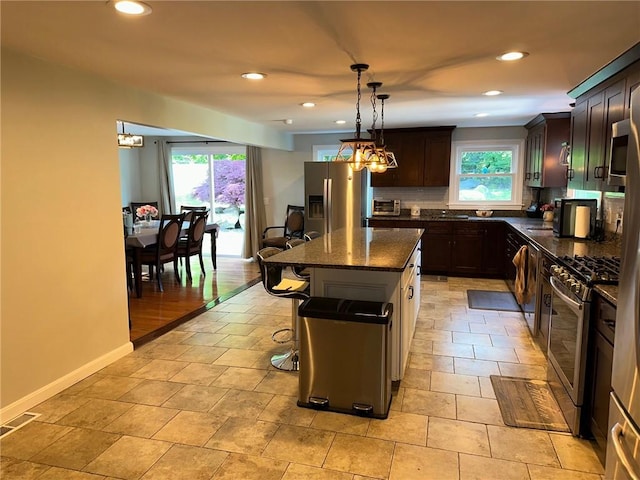 21 Baldwin Rd, Warwick, RI 02886 - kitchen featuring appliances with stainless steel finishes, tasteful backsplash, recessed lighting, a kitchen bar, and a kitchen island