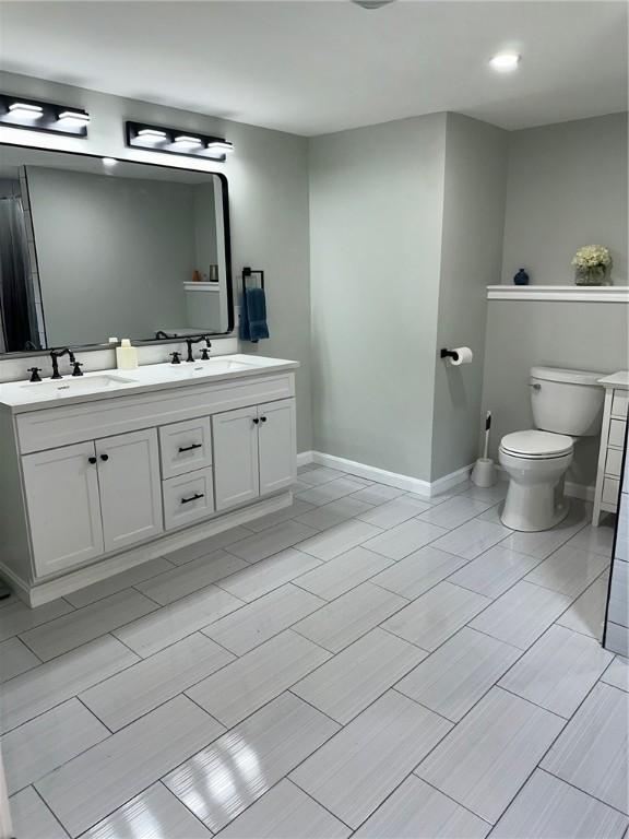 21 Baldwin Rd, Warwick, RI 02886 - full bathroom featuring double vanity, toilet, and baseboards