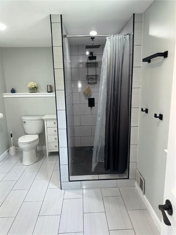 21 Baldwin Rd, Warwick, RI 02886 - bathroom featuring baseboards, toilet, and a stall shower