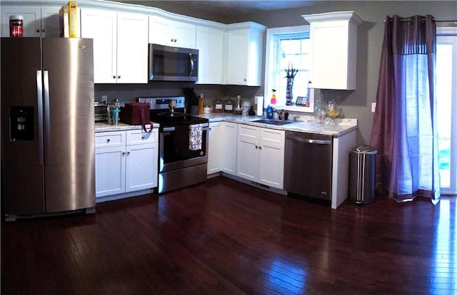 71 Carlton St, Cranston, RI 02910 - kitchen with stainless steel appliances, a sink, dark wood-style flooring, light countertops, and white cabinetry