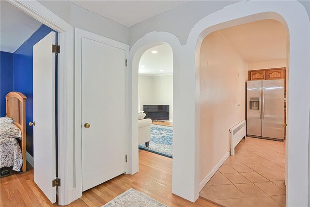822 Cottage St, Pawtucket, RI 02861 - corridor featuring arched walkways, radiator, and light wood finished floors