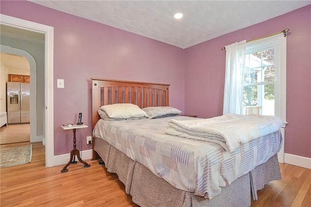 822 Cottage St, Pawtucket, RI 02861 - bedroom with stainless steel fridge with ice dispenser, baseboards, arched walkways, light wood-style flooring, and recessed lighting