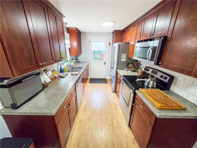 294 Railroad Ave, North Kingstown, RI 02874 - kitchen with stainless steel appliances, light wood-style floors, tasteful backsplash, a sink, and baseboards