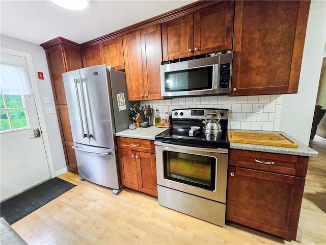 294 Railroad Ave, North Kingstown, RI 02874 - kitchen with appliances with stainless steel finishes, tasteful backsplash, and light wood-style floors