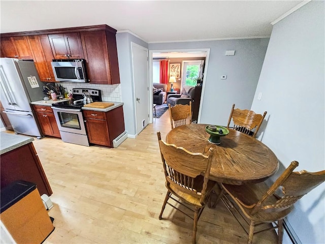 294 Railroad Ave, North Kingstown, RI 02874 - kitchen with appliances with stainless steel finishes, decorative backsplash, light countertops, ornamental molding, and light wood finished floors